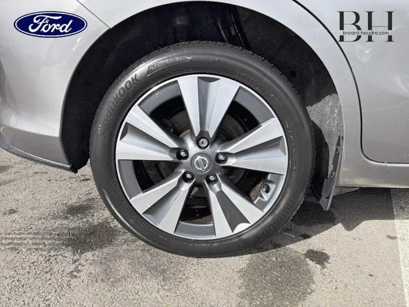 Gros plan sur la roue avant droite d'une Nissan Pulsar bronze ultime, avec jante alu et logo Nissan visible.