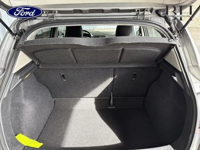 Coffre ouvert vu de l'arrière d'une Nissan Pulsar bronze ultime, montrant l'espace de chargement et la tablette cache-bagages.