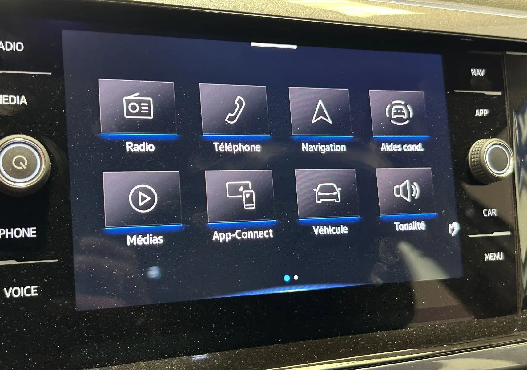 Écran tactile central du Volkswagen Taigo TSI 110 DSG7 Style 2022 affichant les menus radio, téléphone, navigation et aides à la conduite.
