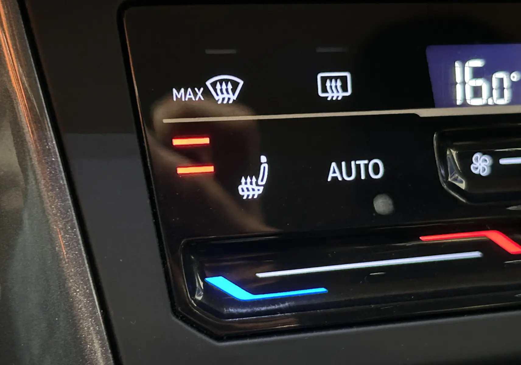 Gros plan sur la commande de climatisation automatique avec siège chauffant dans un Volkswagen Taigo blanc.