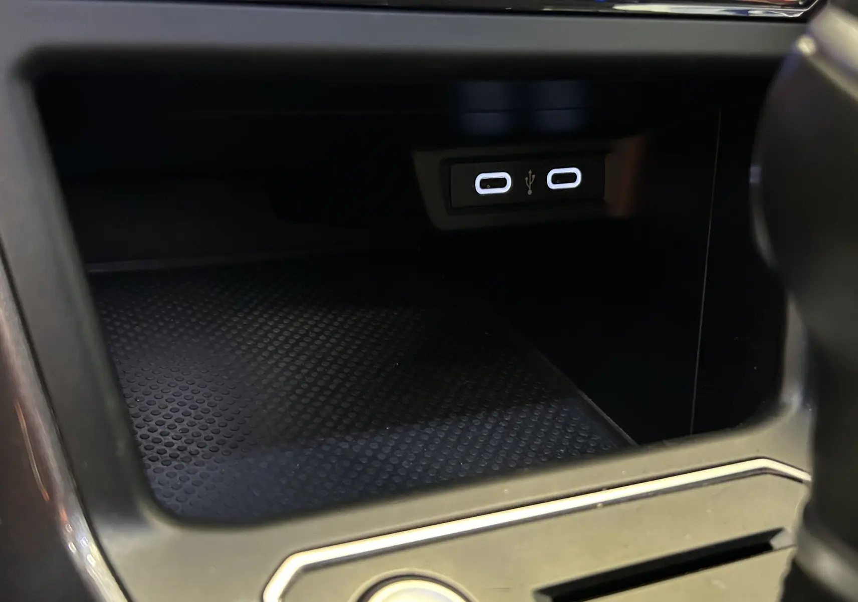 Gros plan sur la console centrale du Volkswagen Taigo blanc, montrant deux ports USB-C éclairés.