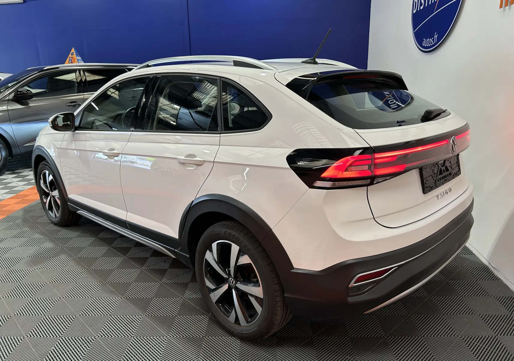 Vue 3/4 arrière droite du Volkswagen Taigo blanc Pur 2022 avec feux arrière LED et jantes alliage bicolores.