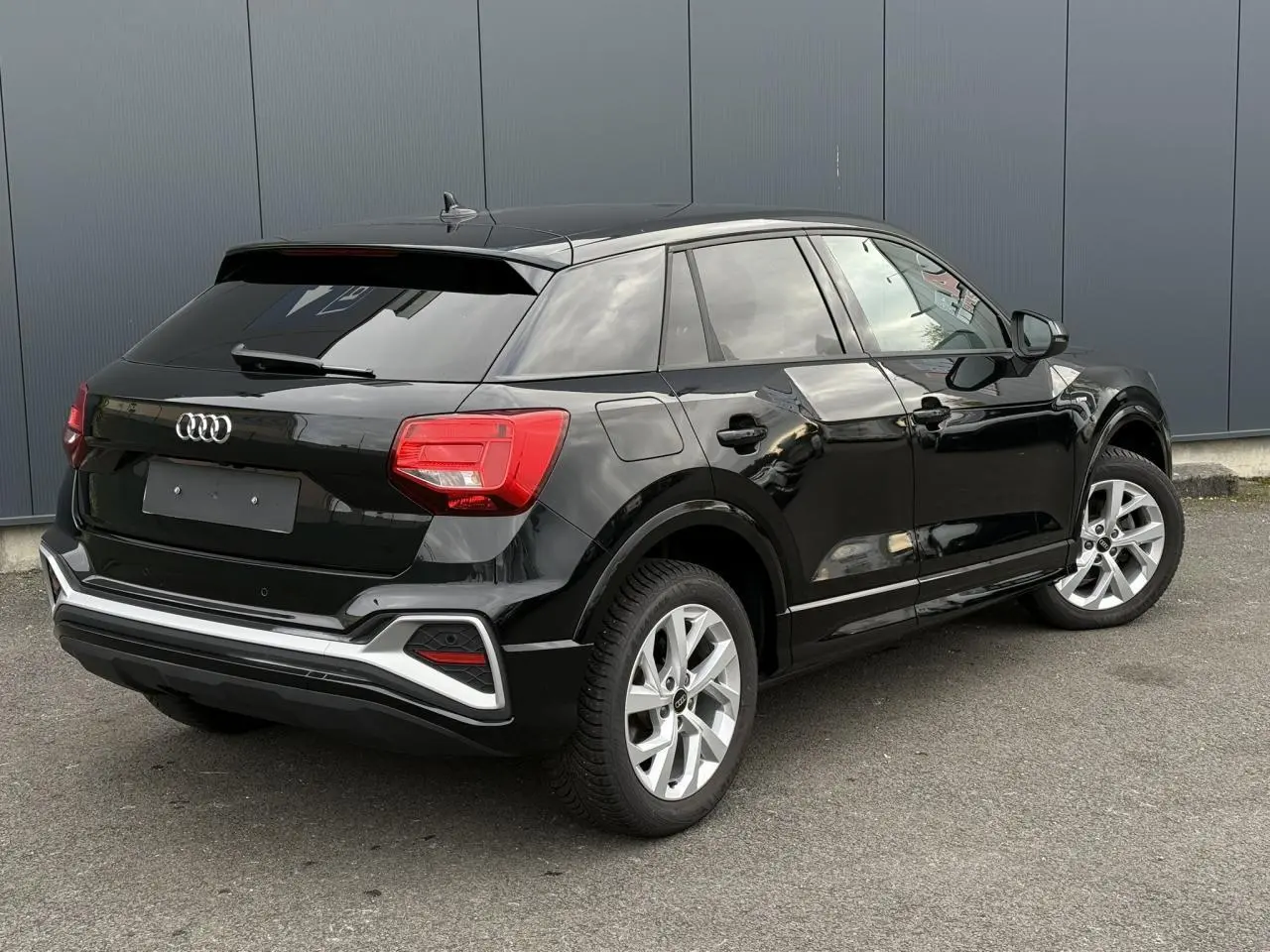 Audi Q2 noir Mythe vue 3/4 arrière droit, avec feux LED et jantes alliage 17 pouces visibles.