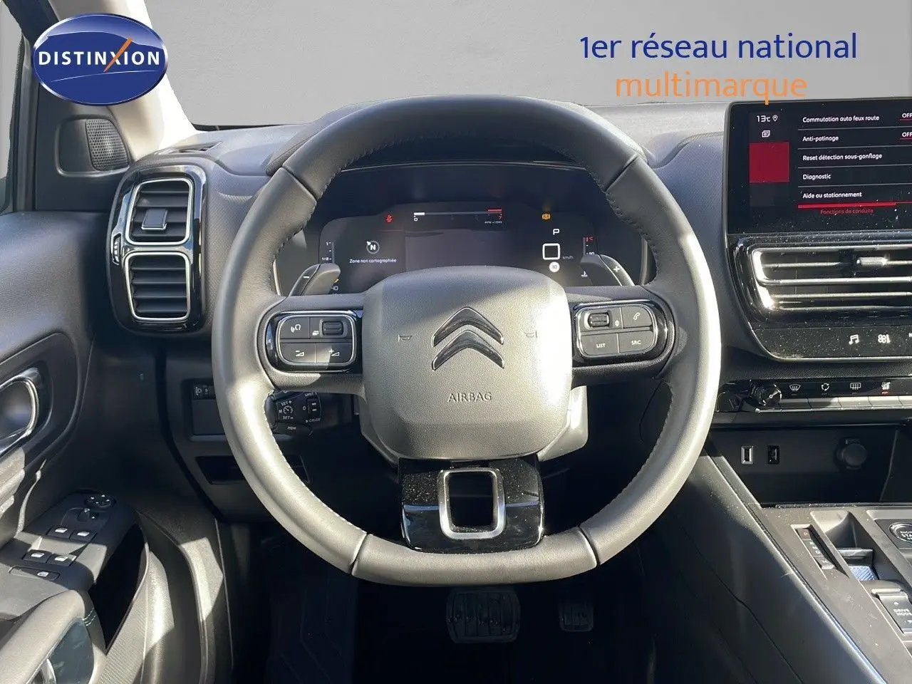 Vue centrée sur le volant cuir noir et tableau de bord numérique du Citroën C5 Aircross 2025, intérieur moderne et épuré.