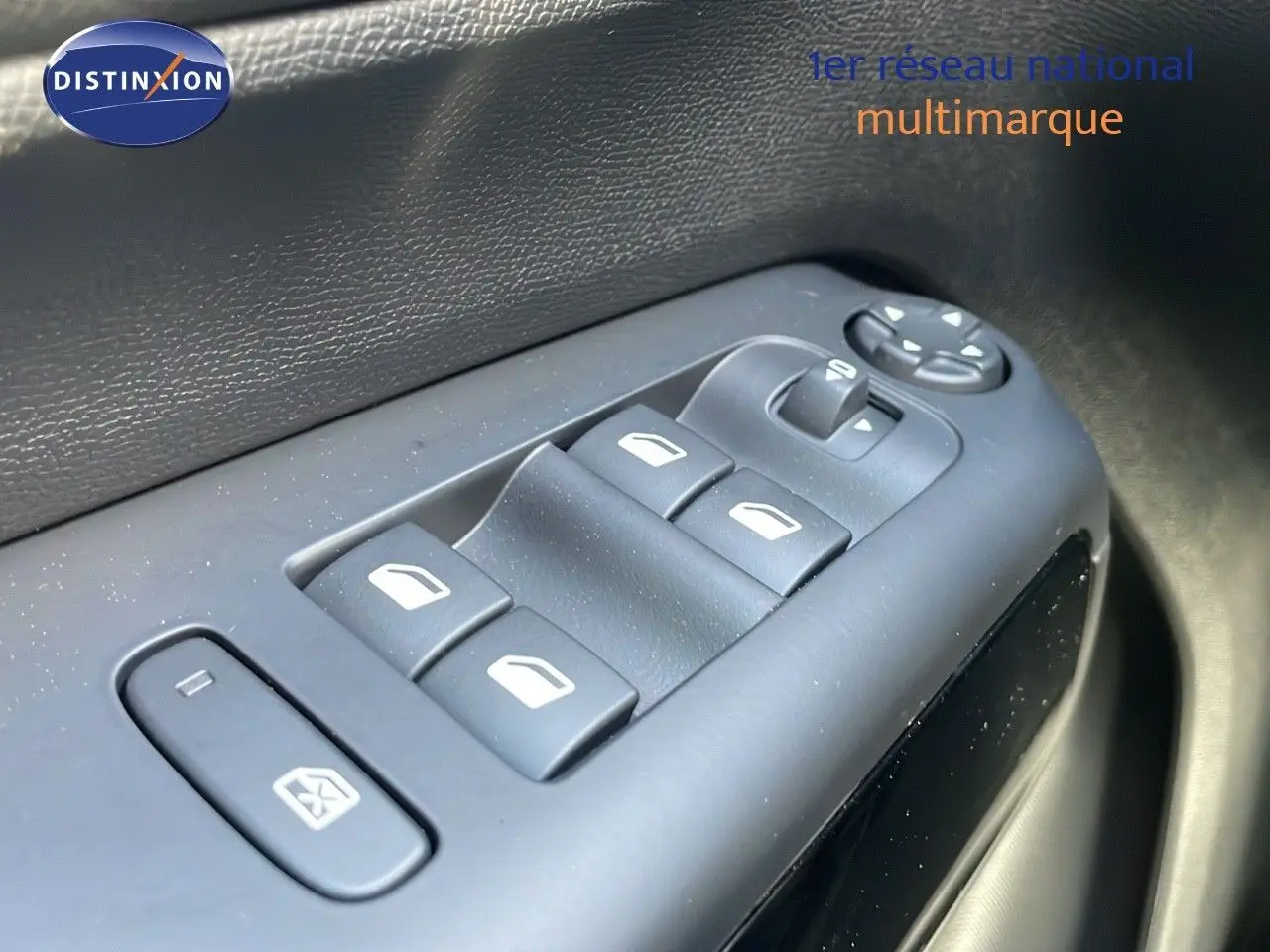 Gros plan sur les commandes des vitres électriques côté conducteur d'un Citroën C5 Aircross bleu Eclipse Metal.