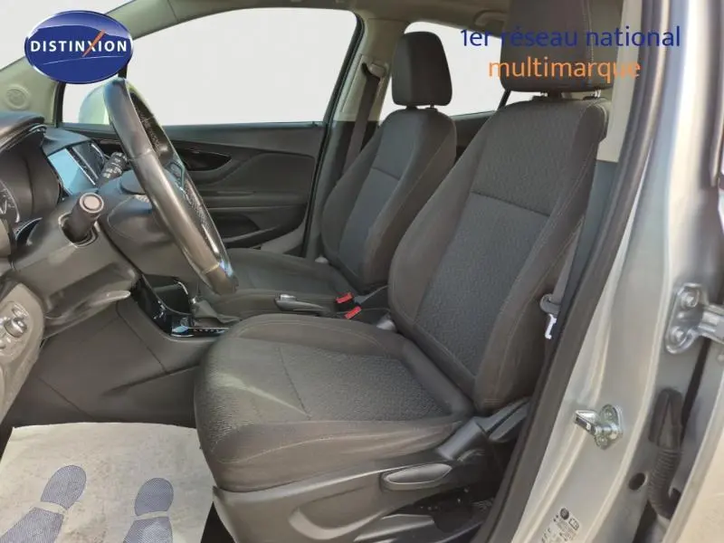 Vue intérieure côté conducteur de l'Opel Mokka X gris minéral, montrant les sièges avant et le volant cuir multifonction.