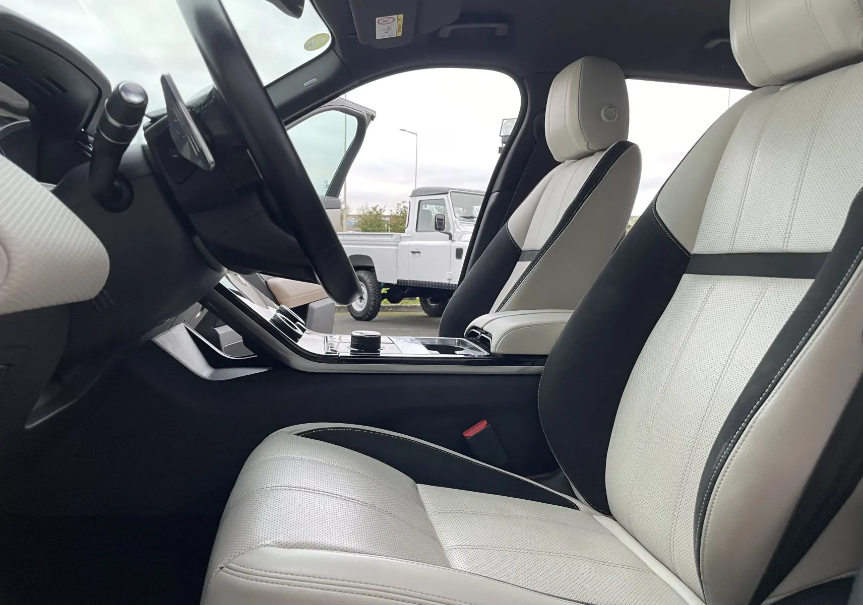 Intérieur du Range Rover Velar D300 2018, vue côté conducteur sur sièges cuir beige et noir avec console centrale moderne.