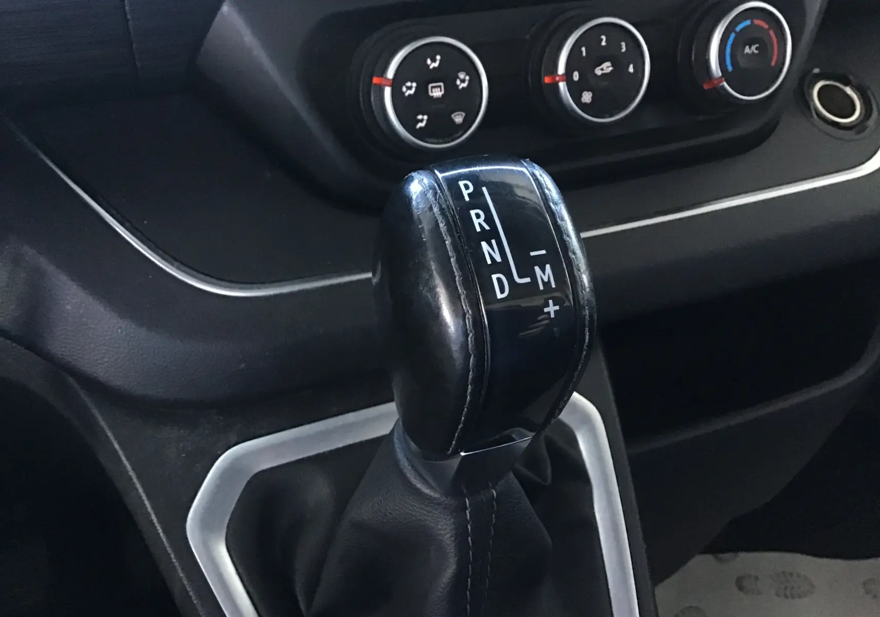 Le levier de vitesses automatique noir du Nissan Primastar Fourgon 2022, avec commandes de climatisation en arrière-plan.