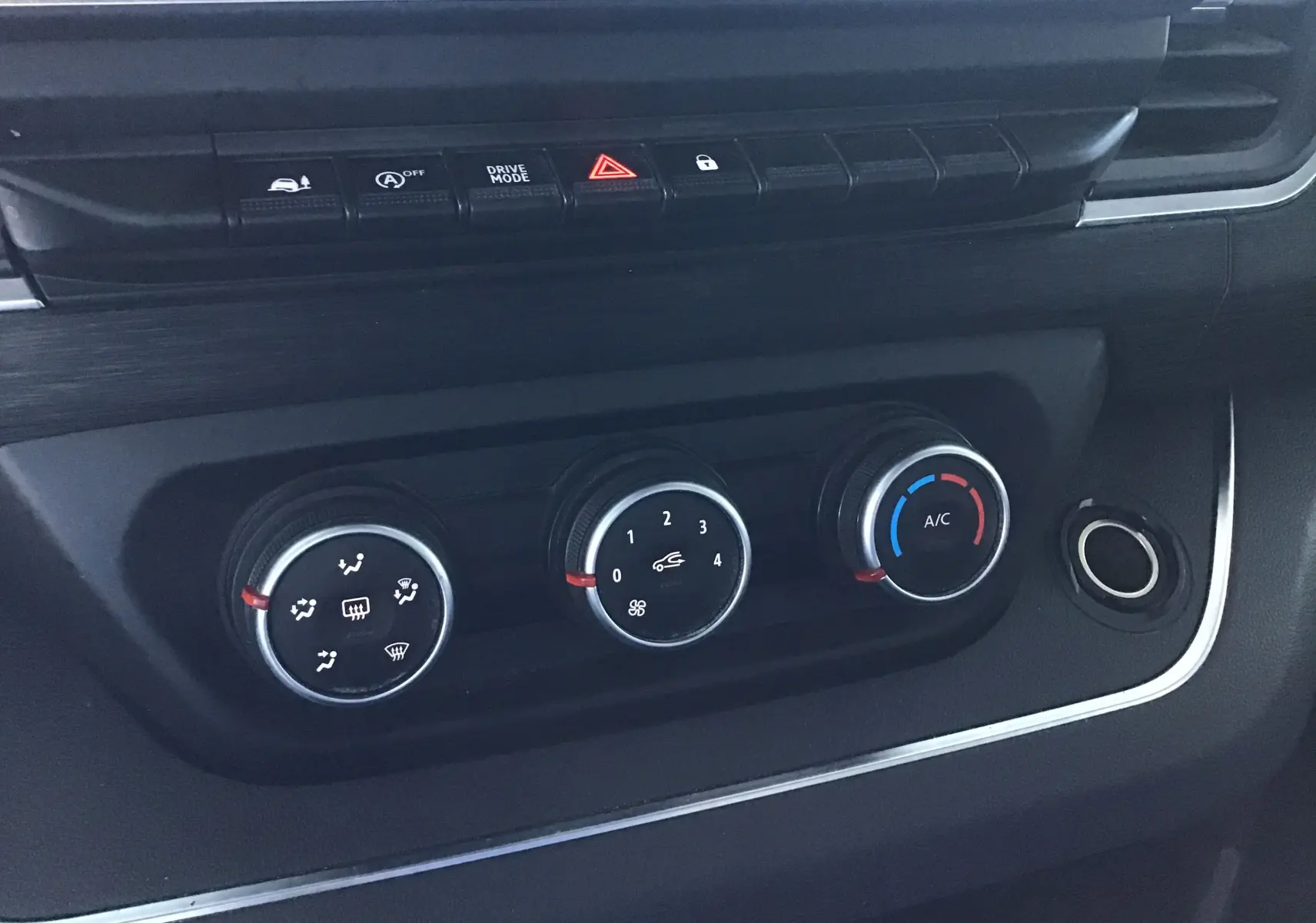 Gros plan sur les commandes de climatisation noires du tableau de bord du Nissan Primastar Fourgon blanc 2022.