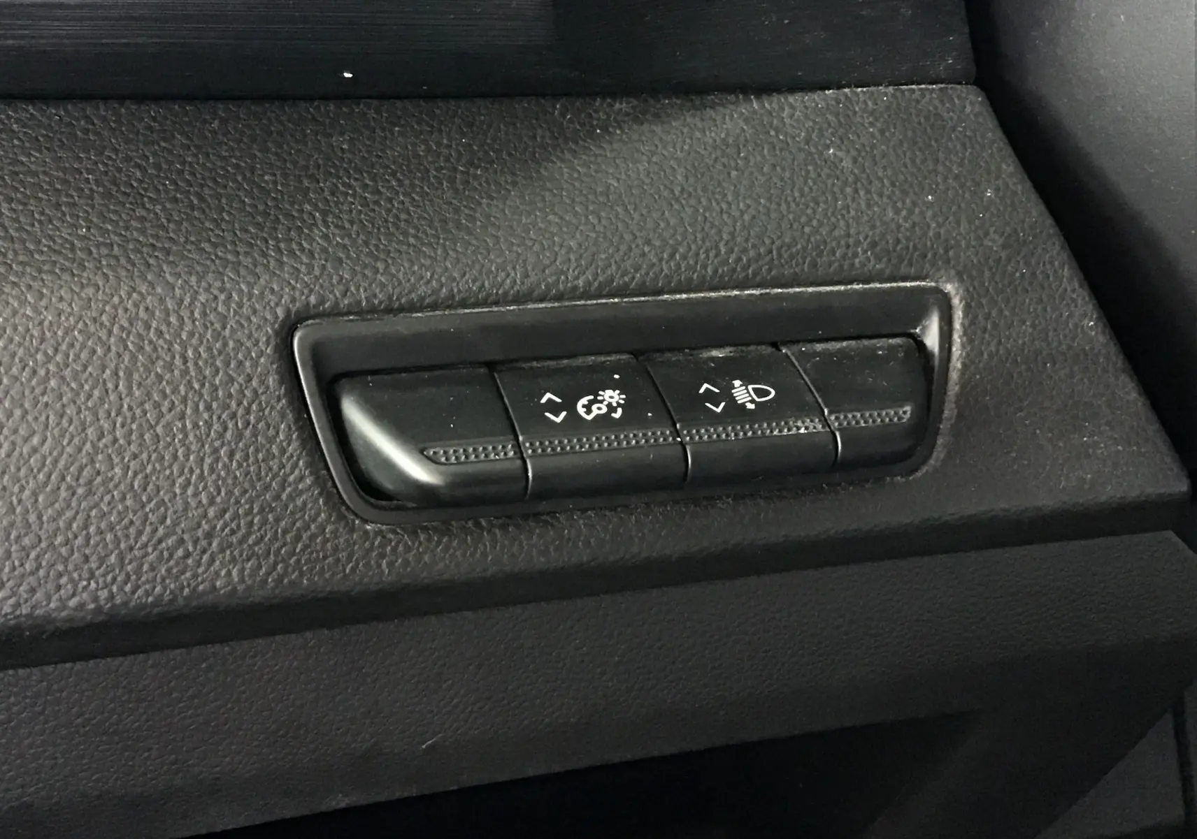 Boutons de réglage de l'éclairage intérieur sur tableau de bord noir du Nissan Primastar Fourgon blanc.