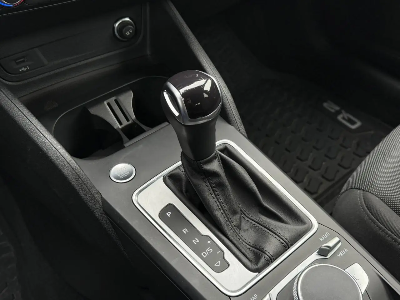 Le levier de vitesse automatique en cuir noir de l'Audi Q2 35 TFSI S-Line, vue rapprochée de la console centrale.