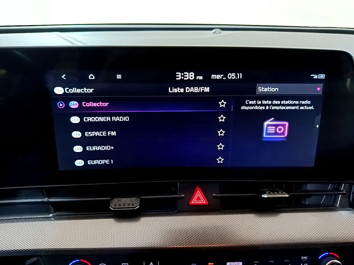 Écran tactile central affichant la liste des stations radio dans l'habitacle du KIA SPORTAGE blanc de 2022.