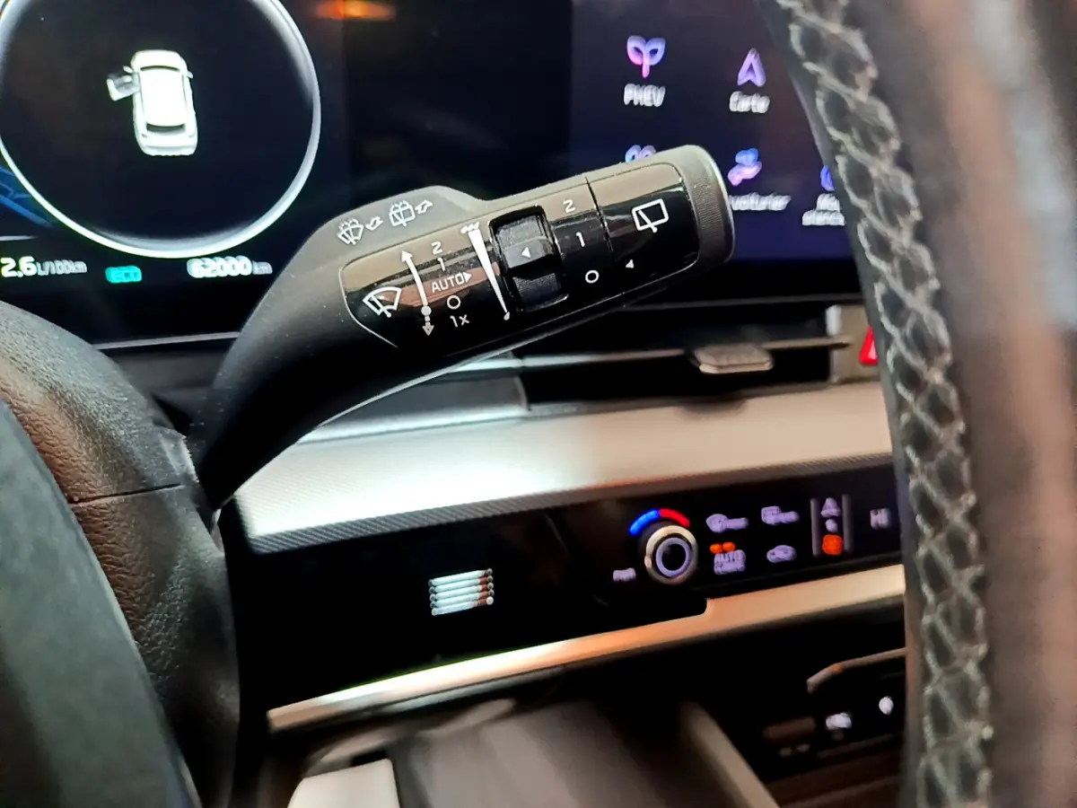 Gros plan sur la commande d’essuie-glace côté gauche du tableau de bord du Kia Sportage blanc hybride rechargeable 2022.