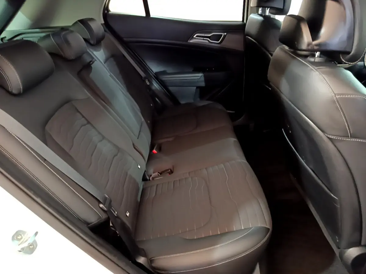 Vue intérieure côté gauche des sièges arrière noirs en cuir du Kia Sportage blanc 2022 hybride rechargeable Design.