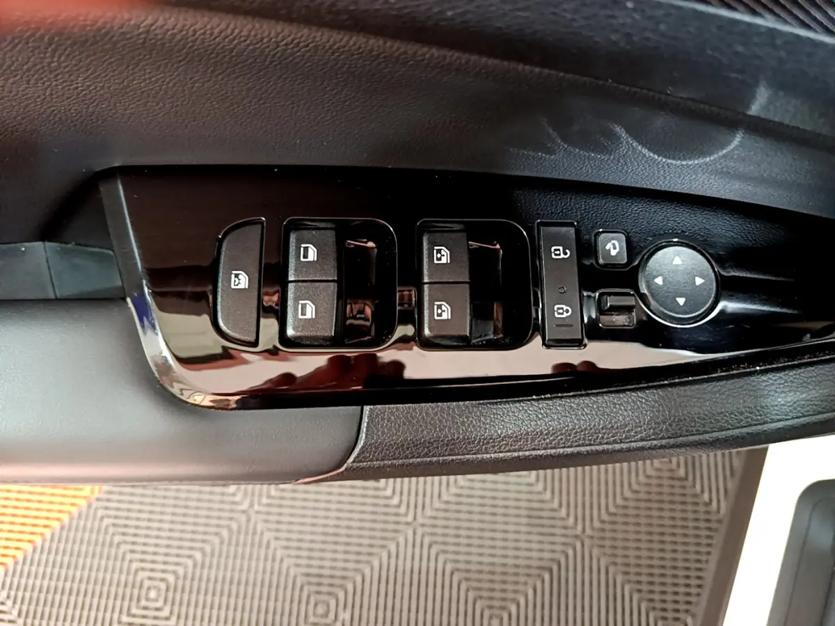Gros plan sur les commandes de lève-vitres et rétroviseurs côté conducteur du KIA SPORTAGE blanc 2022.