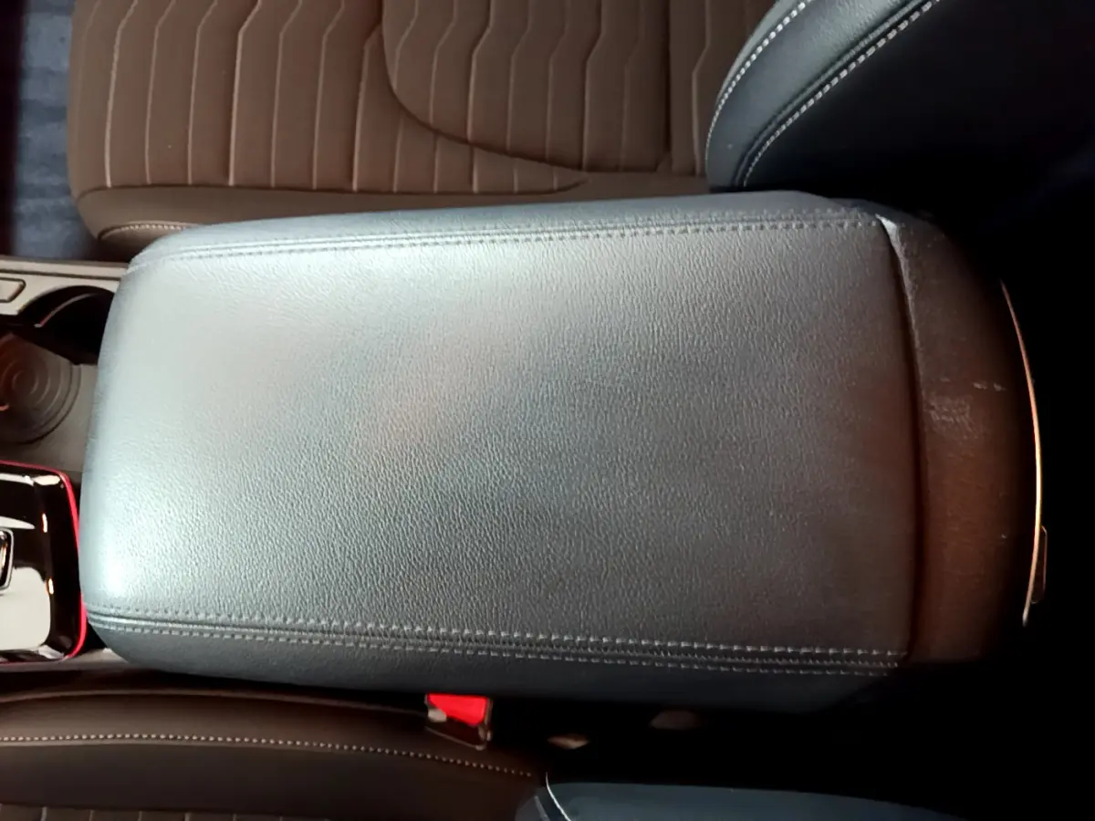 Vue rapprochée de l'accoudoir central en cuir noir du Kia Sportage hybride rechargeable blanc 2022.