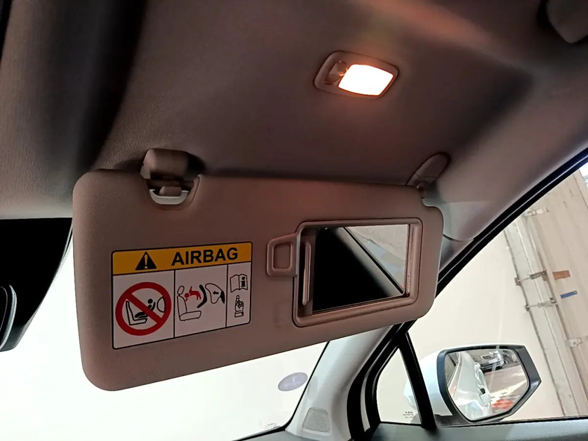Détail du pare-soleil côté conducteur avec miroir ouvert dans l'habitacle du Kia Sportage blanc 2022.