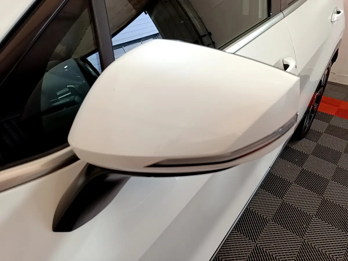 Rétroviseur blanc côté gauche du Kia Sportage 2022 hybride rechargeable, avec clignotant intégré, vue rapprochée.