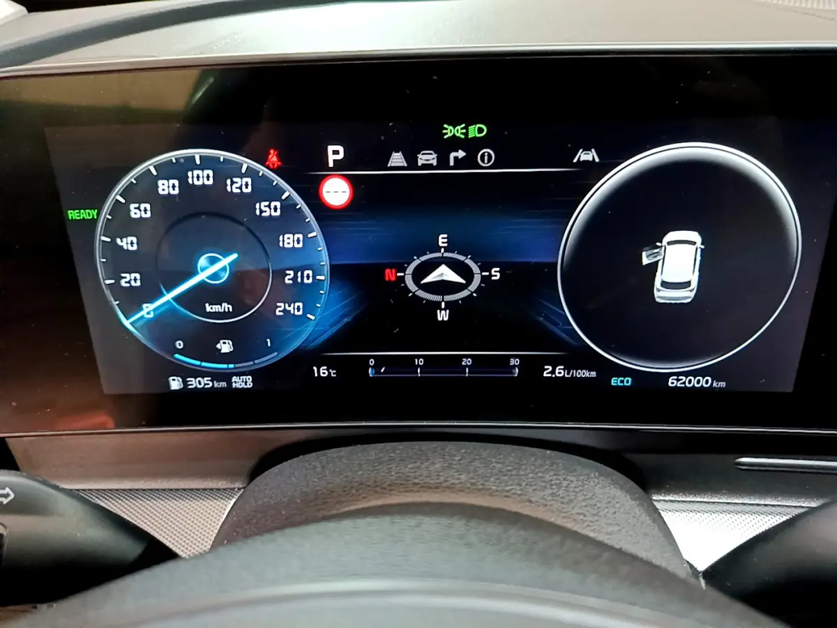 Tableau de bord numérique du Kia Sportage 2022, affichage vitesse, boussole et état portes vu de face.