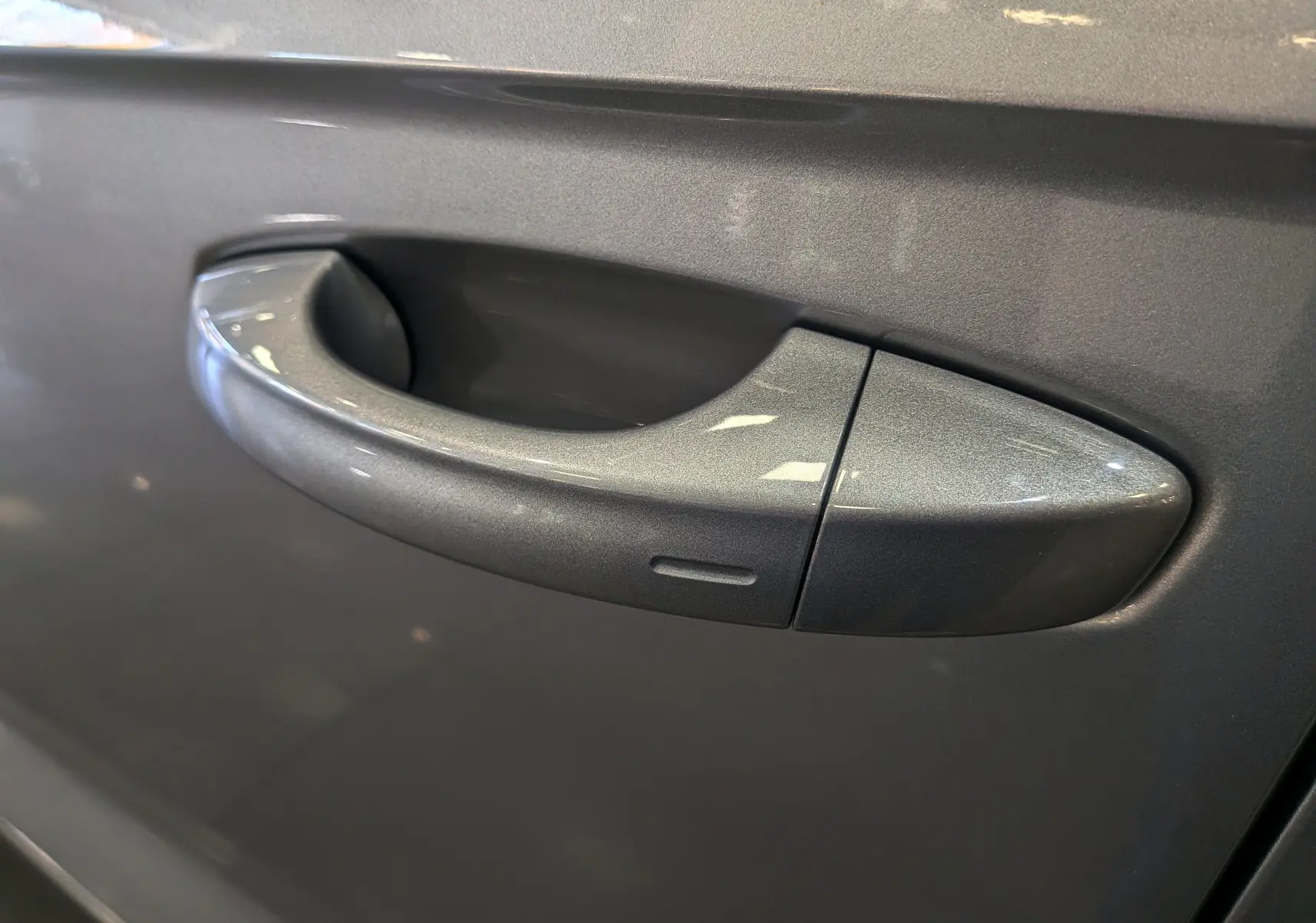 Poignée de porte gris pyrite du Volkswagen T-Roc 2024, mettant en valeur la finition lisse et la teinte métallisée.