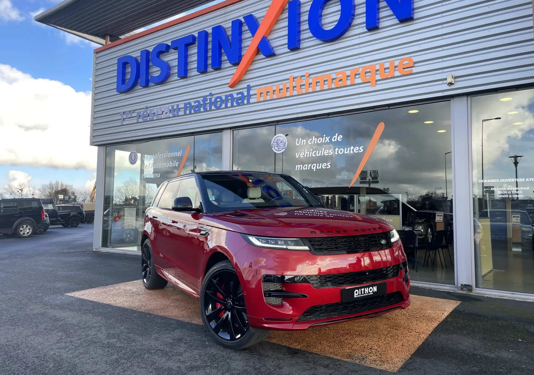 Vue 3/4 avant gauche d’un Range Rover Sport P440 HSE R-Dynamic hybride en Italian Racing Red, avec jantes alu noires 23 pouces.