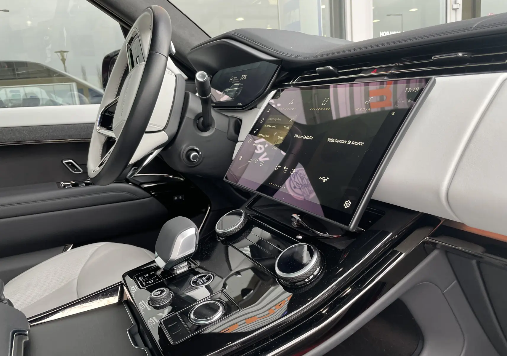 Intérieur côté conducteur du Range Rover Sport P440 HSE R-Dynamic 2023, cuir blanc et écran tactile central incliné.