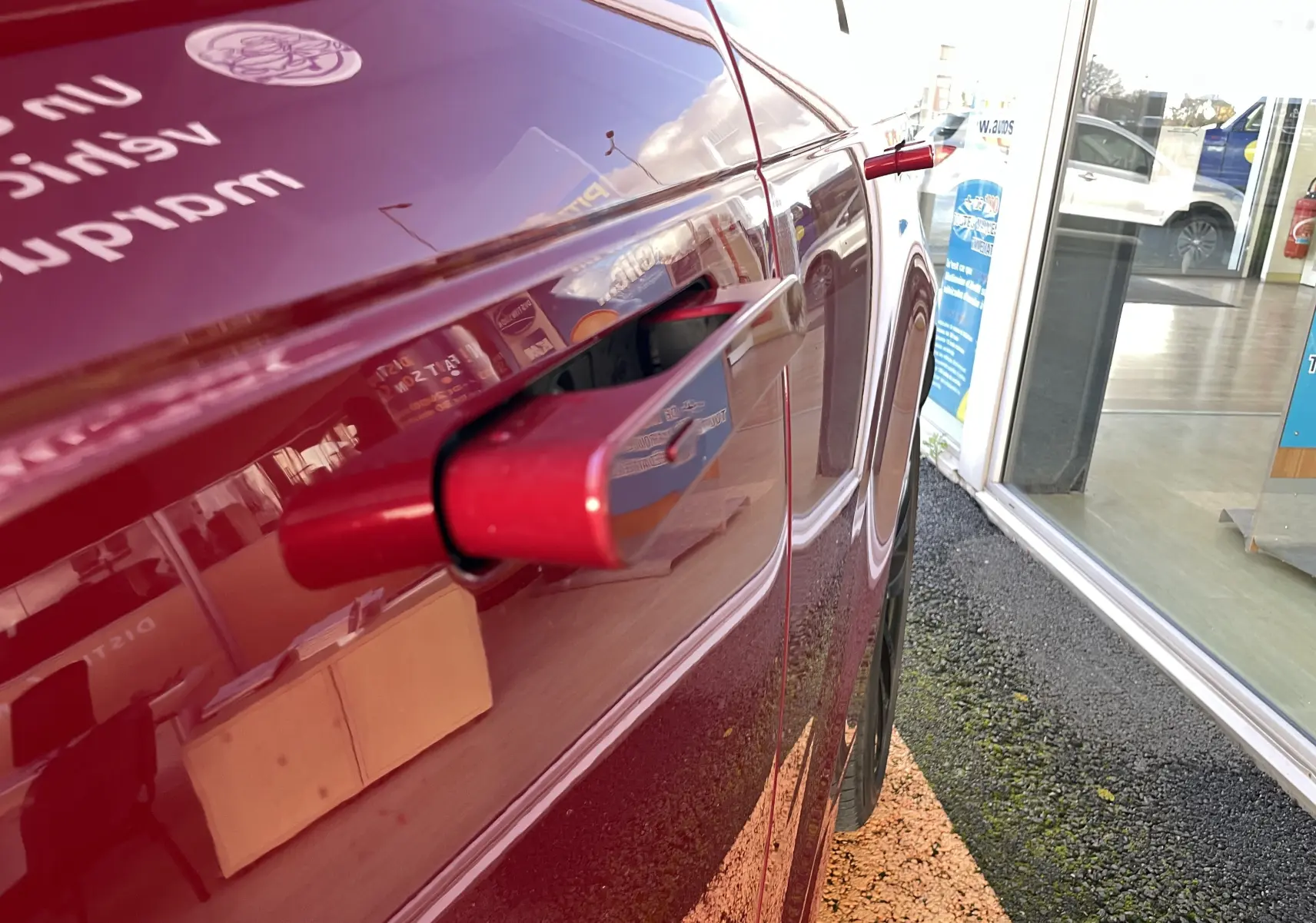 Gros plan sur la poignée de porte rétractable côté gauche du Range Rover Sport P440 HSE R-Dynamic en Italian Racing Red.