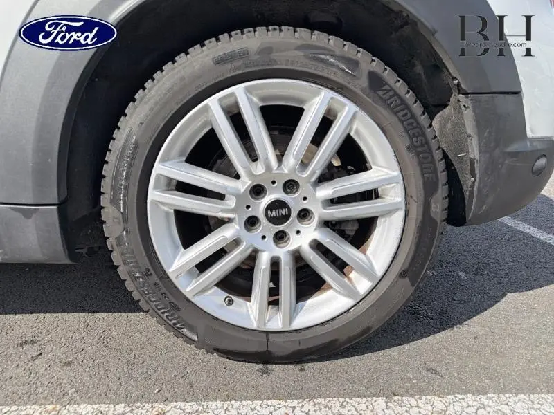 Gros plan sur la roue avant droite en alliage argenté d'une MINI Countryman Moonwalk Grey hybride rechargeable.