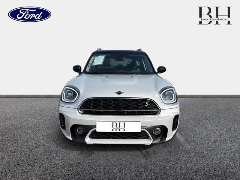 Vue avant d'une MINI Countryman Cooper SE Moonwalk Grey avec calandre noire et détails chromés sur un fond neutre.