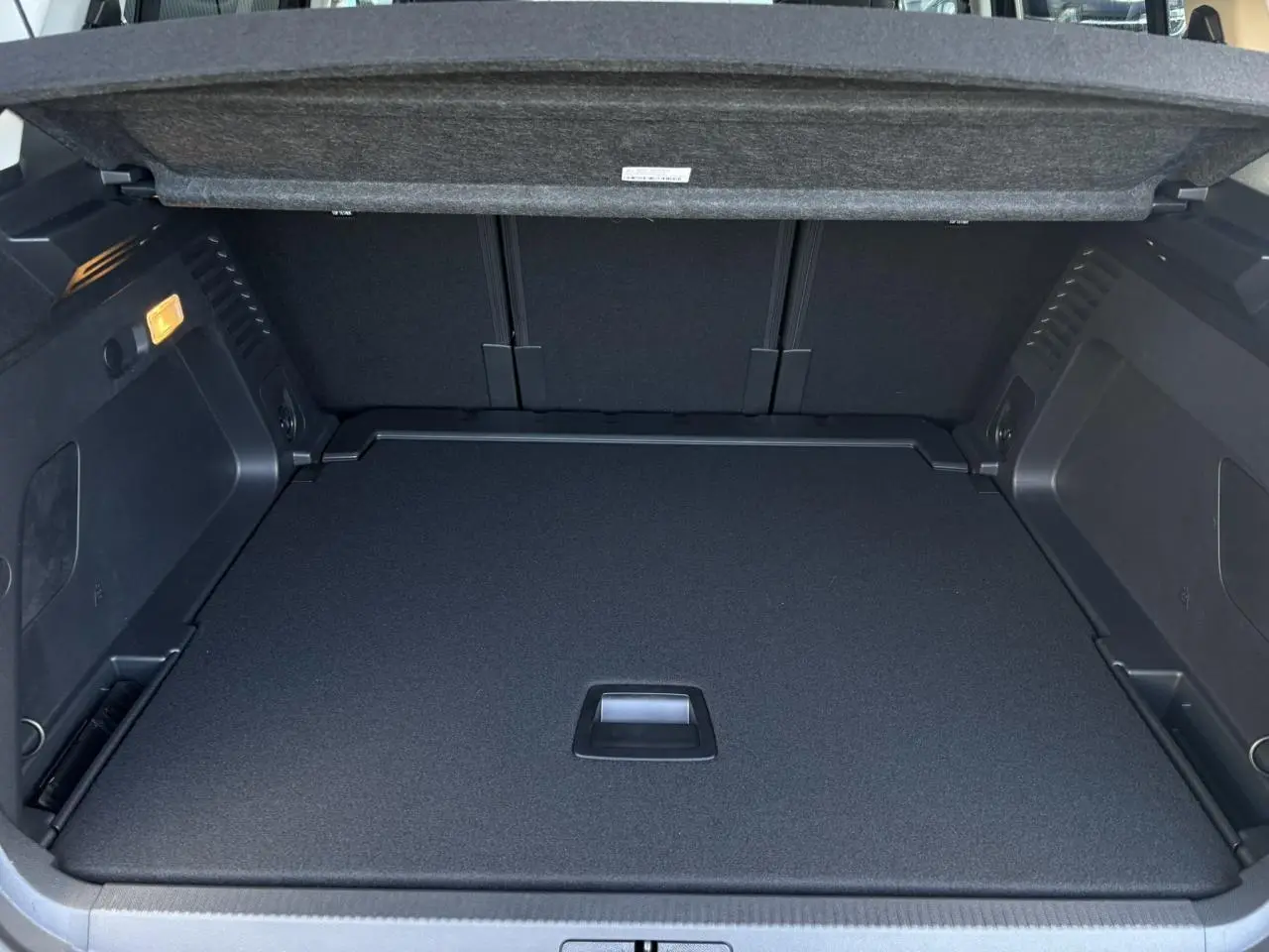 Coffre ouvert du Citroën C5 Aircross gris Platinium, montrant le plancher modulable et l'intérieur noir.