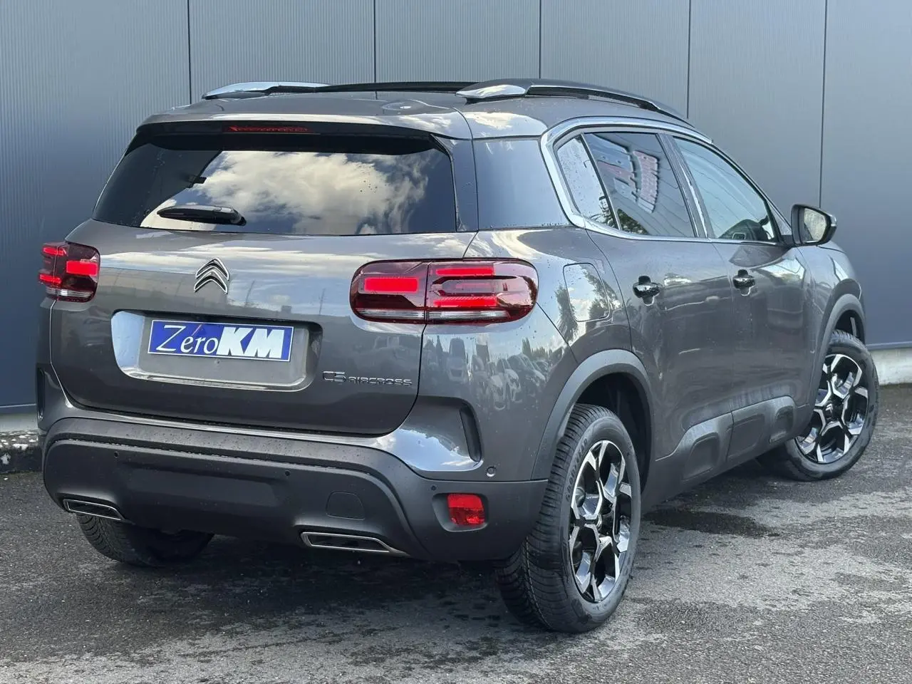 Vue 3/4 arrière droite d'un Citroën C5 Aircross gris Platinium avec jantes alliage et hayon électrique.