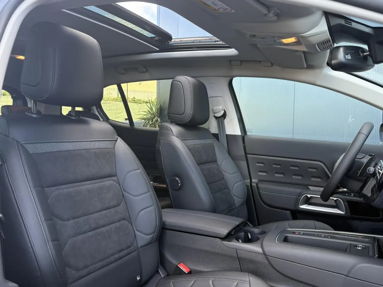 Intérieur du Citroën C5 Aircross 2025 vu côté droit, sièges Urban Black Alcantara noir et toit ouvrant panoramique ouvert.