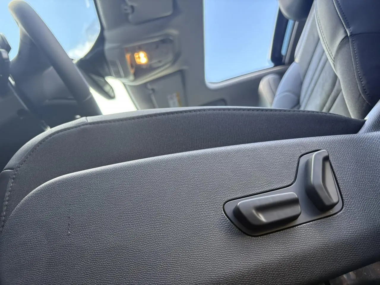 Gros plan sur les commandes électriques du siège conducteur noir Alcantara dans l'habitacle du Citroën C5 Aircross 2025.