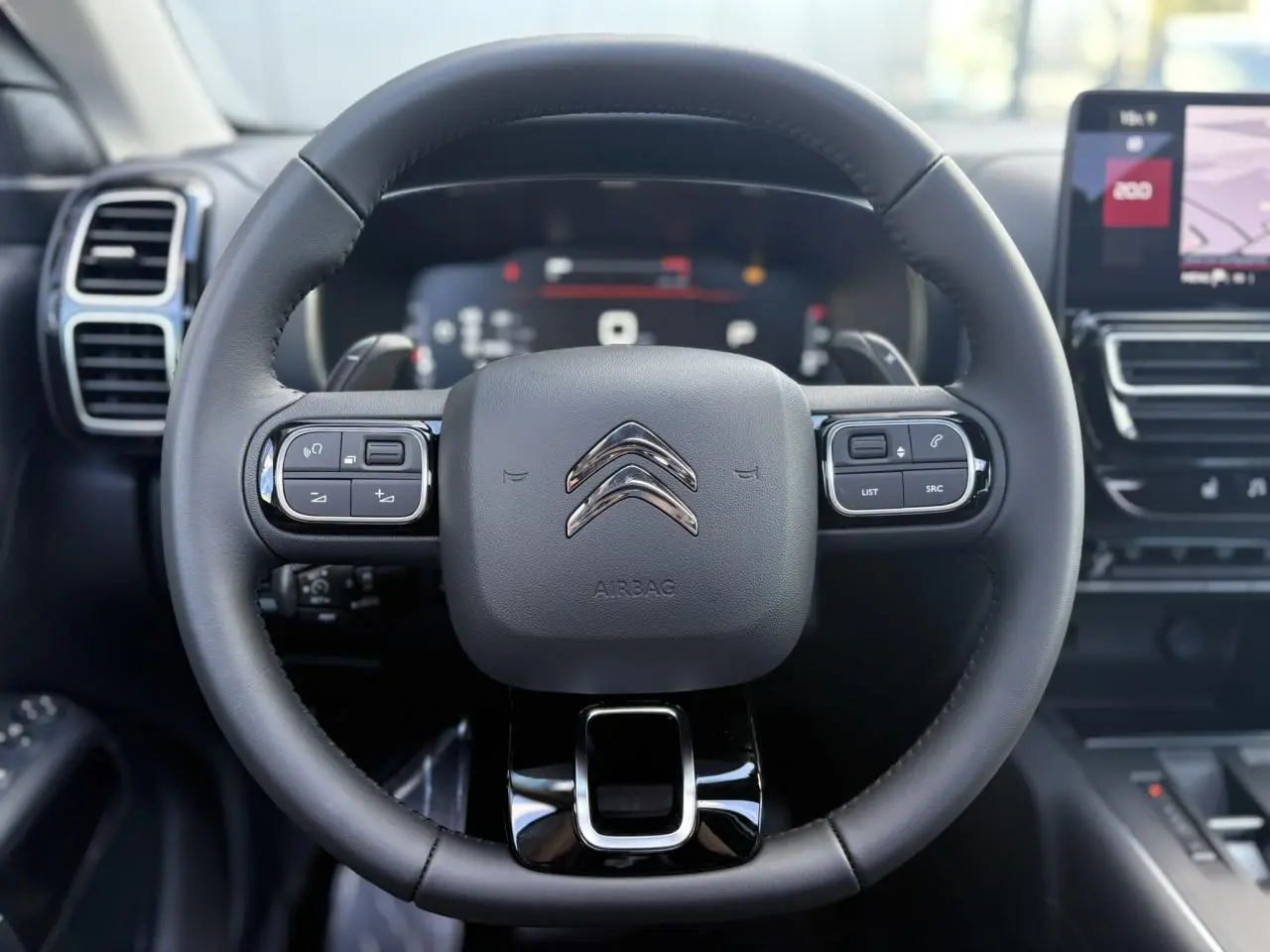Volant en cuir noir de Citroën C5 Aircross 2025, vue frontale avec commandes intégrées et tableau de bord numérique.