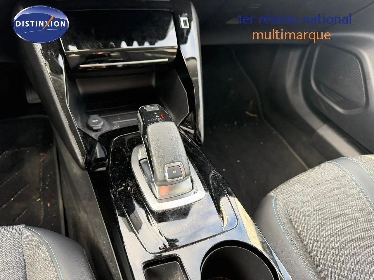 Gros plan sur la console centrale avec levier de vitesse automatique d’une Peugeot 2008 gris Artense, intérieur tissu et cuir noir.