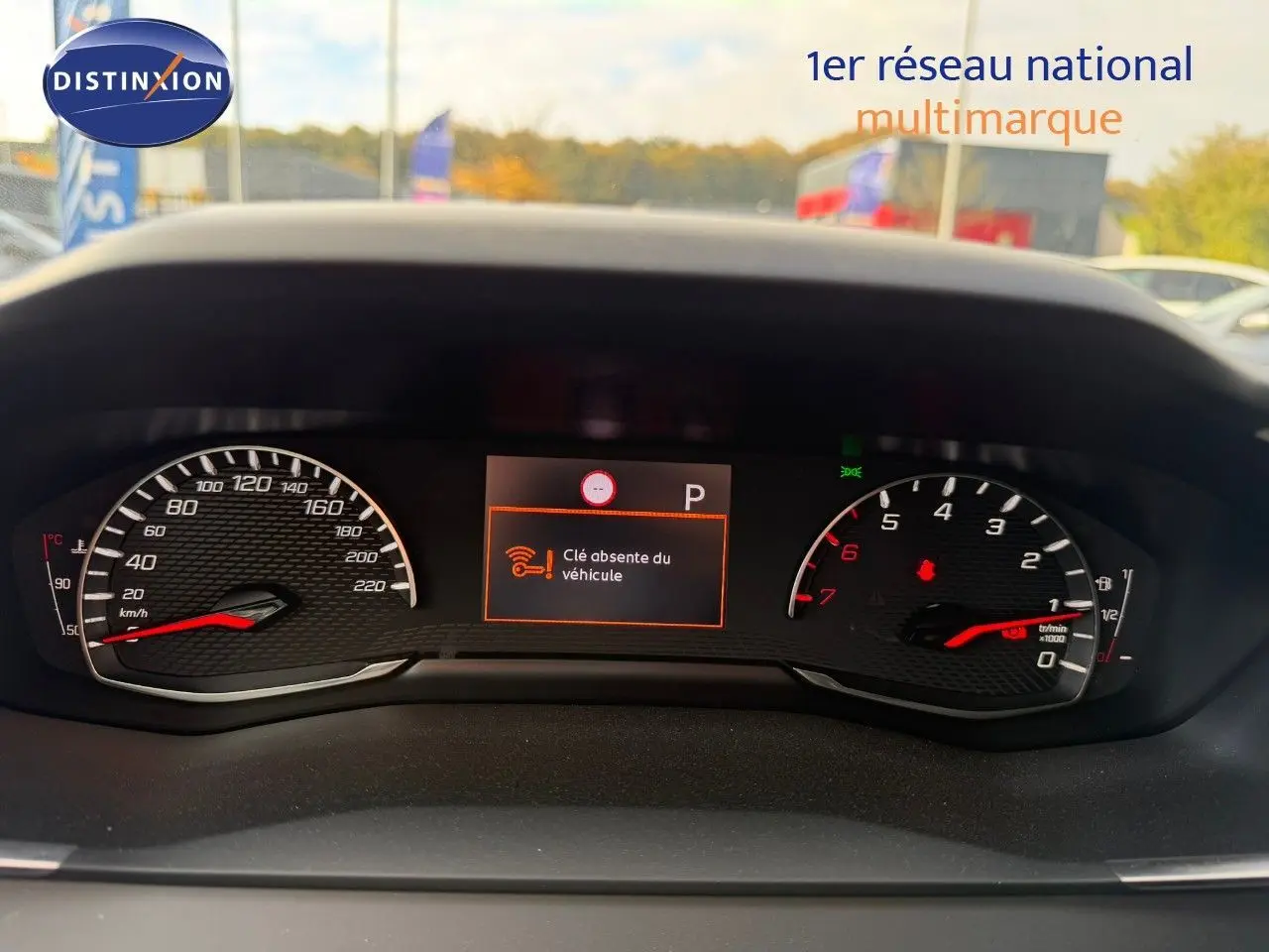 Vue rapprochée du tableau de bord du Peugeot 2008 gris Artense, affichant le compteur et un message d'alerte clé absente.