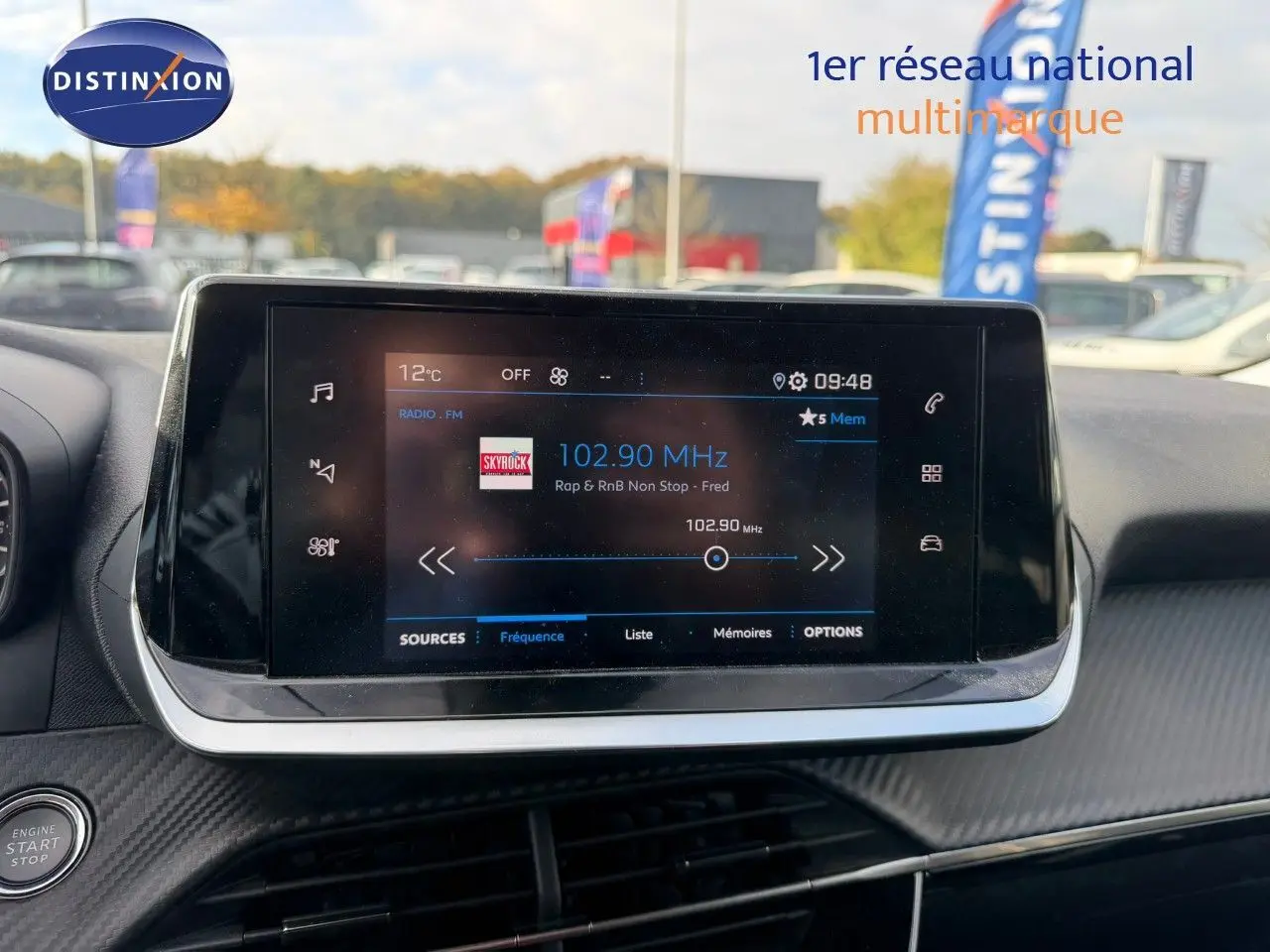 Écran tactile central du tableau de bord du Peugeot 2008 gris Artense, affichant la radio FM à 102,90 MHz.