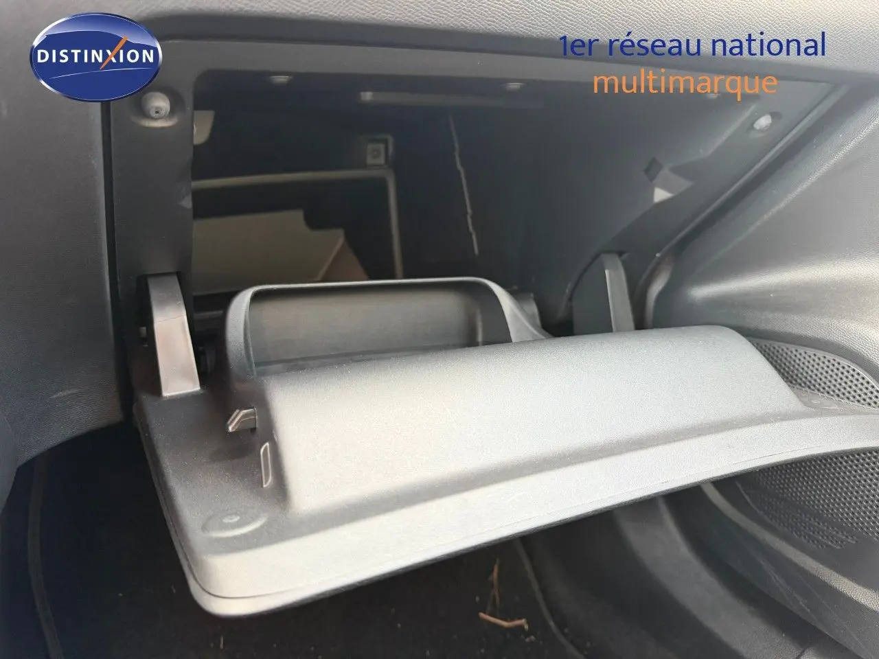 Vue rapprochée de la boîte à gants ouverte dans l’habitacle d’une Peugeot 2008 gris Artense 2022.