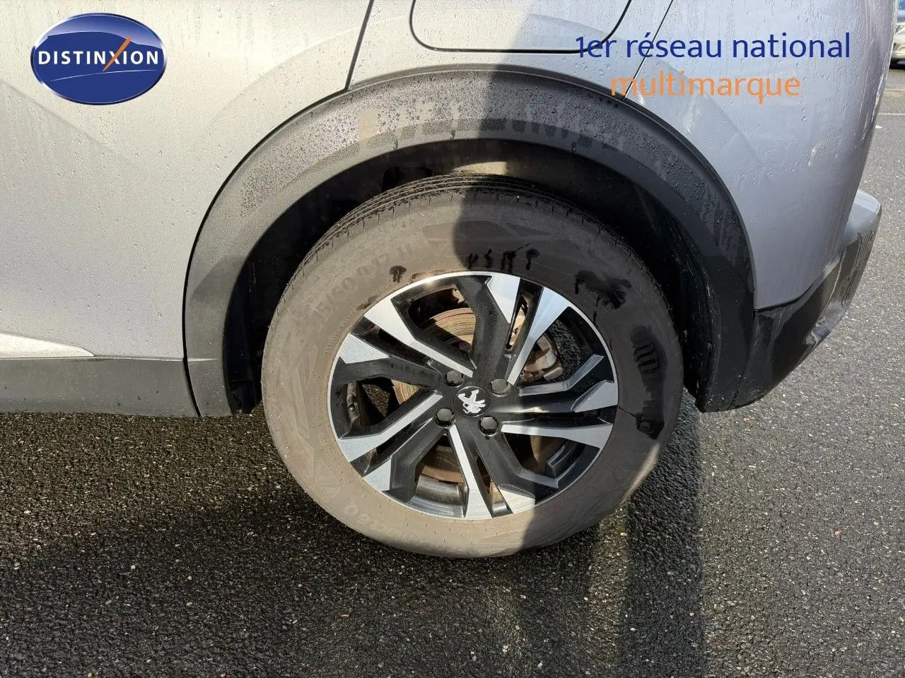 Gros plan sur la roue arrière droite d'un Peugeot 2008 gris Artense, mettant en valeur la jante alliage noire et argentée.