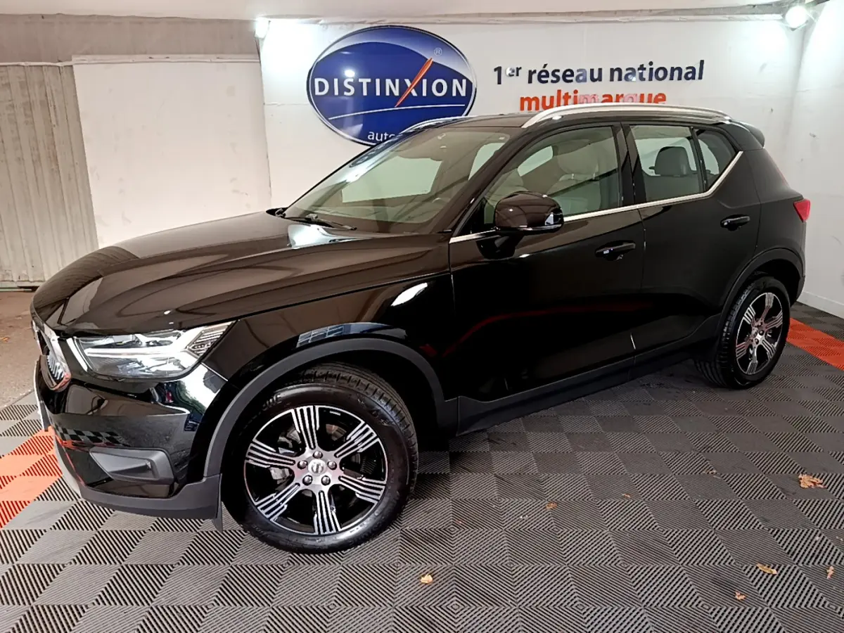 Volvo XC40 T3 Inscription noir vu de profil côté gauche dans un showroom avec jantes alliage et toit chromé.