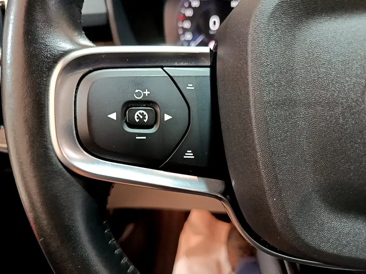 Gros plan sur les commandes de régulateur de vitesse au volant cuir noir du Volvo XC40 T3 Inscription 2020.