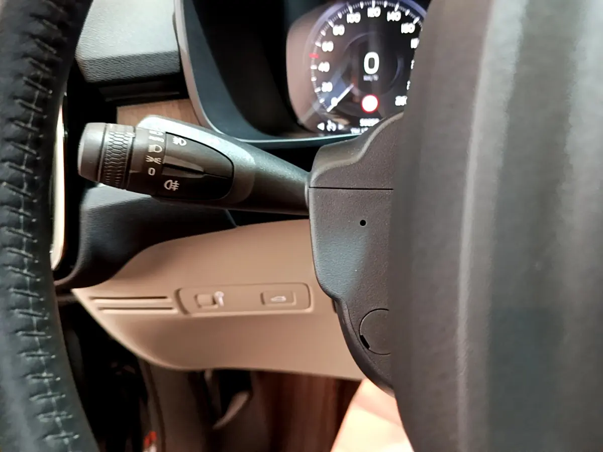 Détail du commodo d'éclairage à gauche du volant cuir noir dans l'habitacle du Volvo XC40 T3 2020.