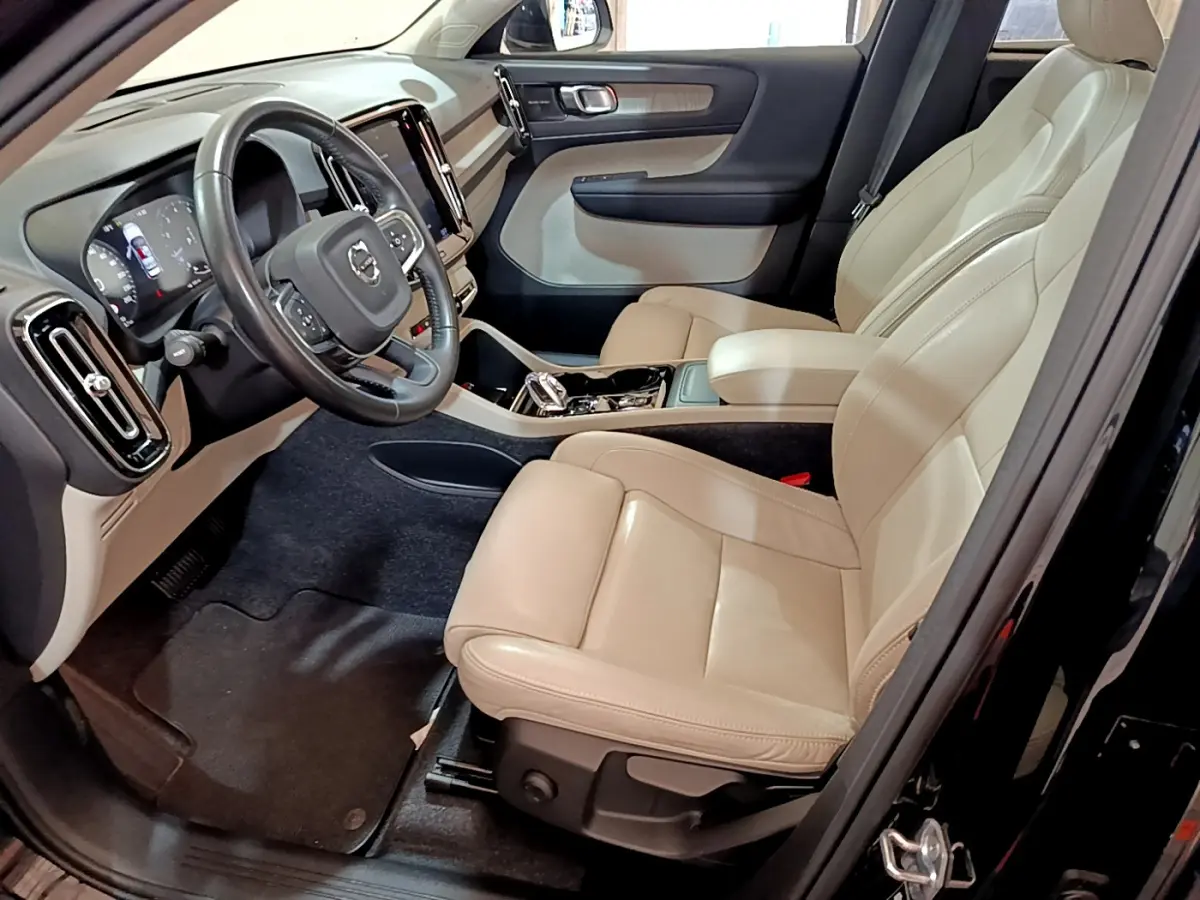 Intérieur beige clair du Volvo XC40 T3 2020 vu côté conducteur, avec tableau de bord et volant multifonctions en cuir.