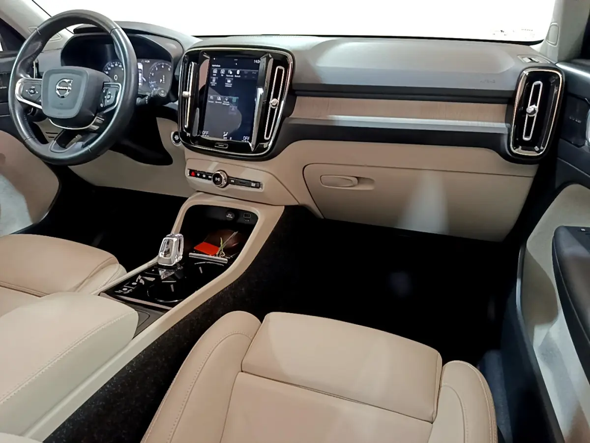 Intérieur clair du Volvo XC40 T3 2020 vu côté passager, avec tableau de bord moderne et écran tactile vertical.