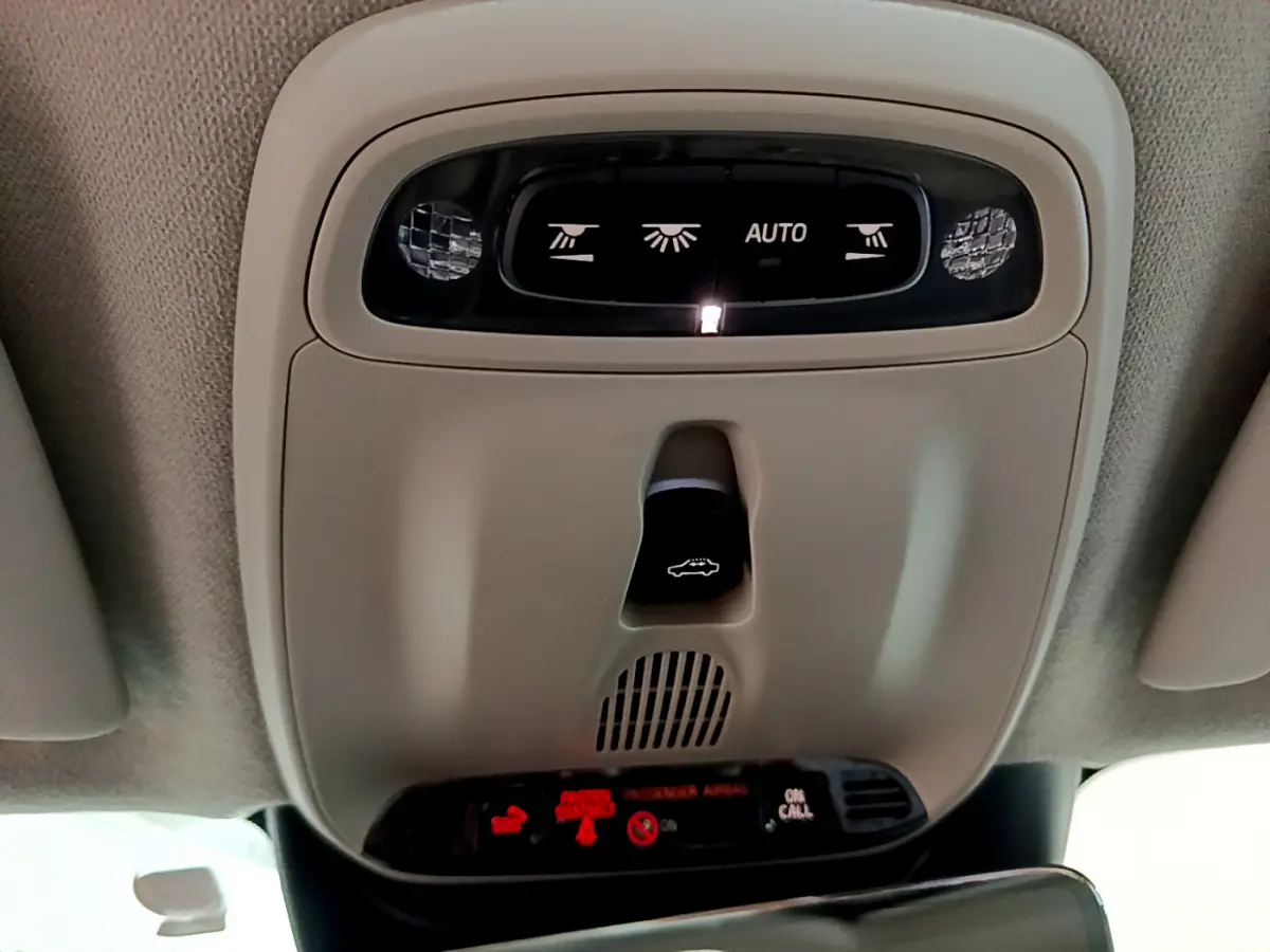 Vue rapprochée du plafonnier beige avec commandes d’éclairage et ouverture du coffre dans un Volvo XC40 noir 2020.