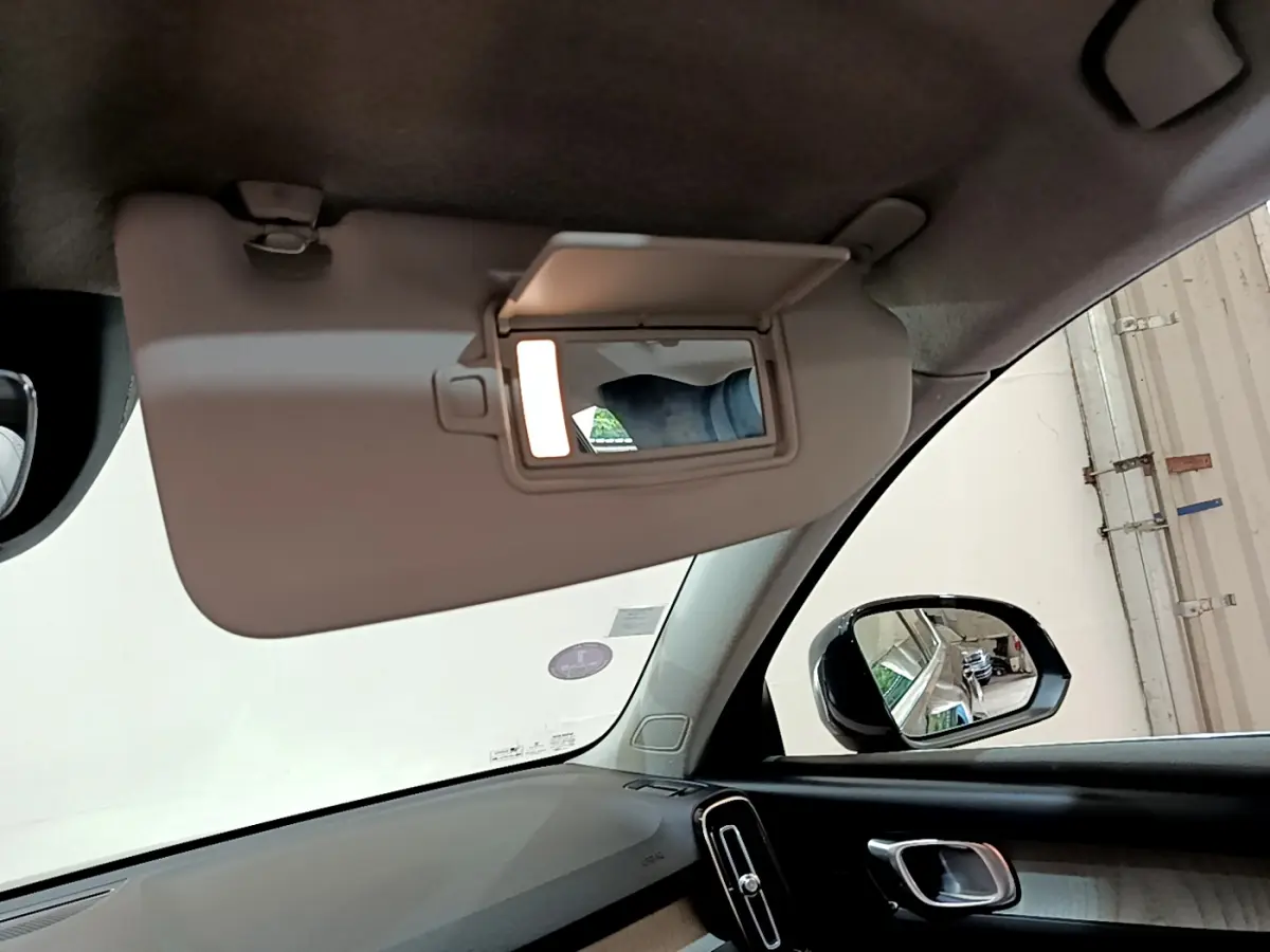 Détail du pare-soleil côté conducteur avec miroir éclairé dans l'habitacle noir du Volvo XC40 T3 2020.
