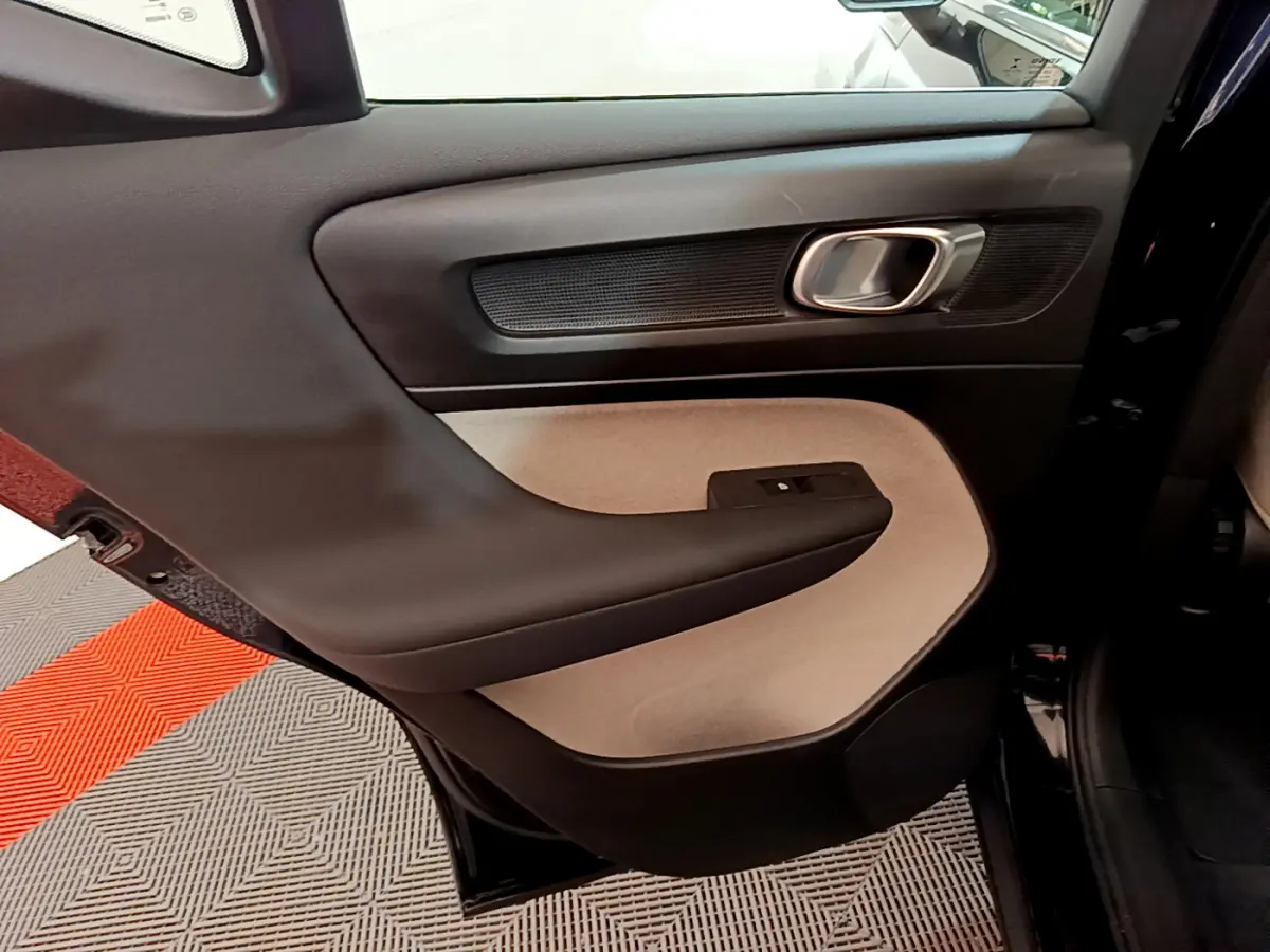 Porte arrière gauche intérieure du Volvo XC40 T3 2020, avec panneau bicolore noir et beige et poignée argentée.