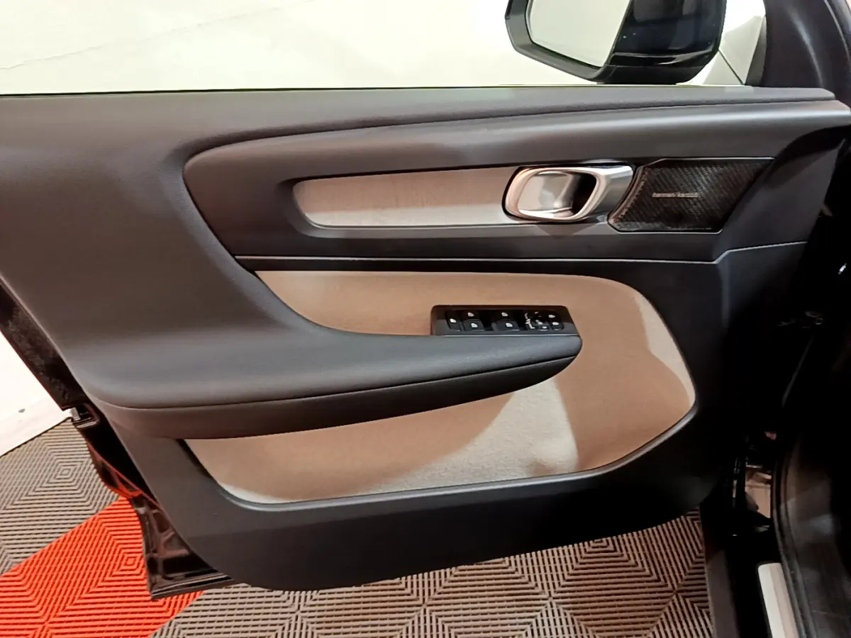 Panneau de porte côté gauche noir et beige du Volvo XC40 T3 2020 avec commande des vitres et haut-parleur Harman Kardon visible.