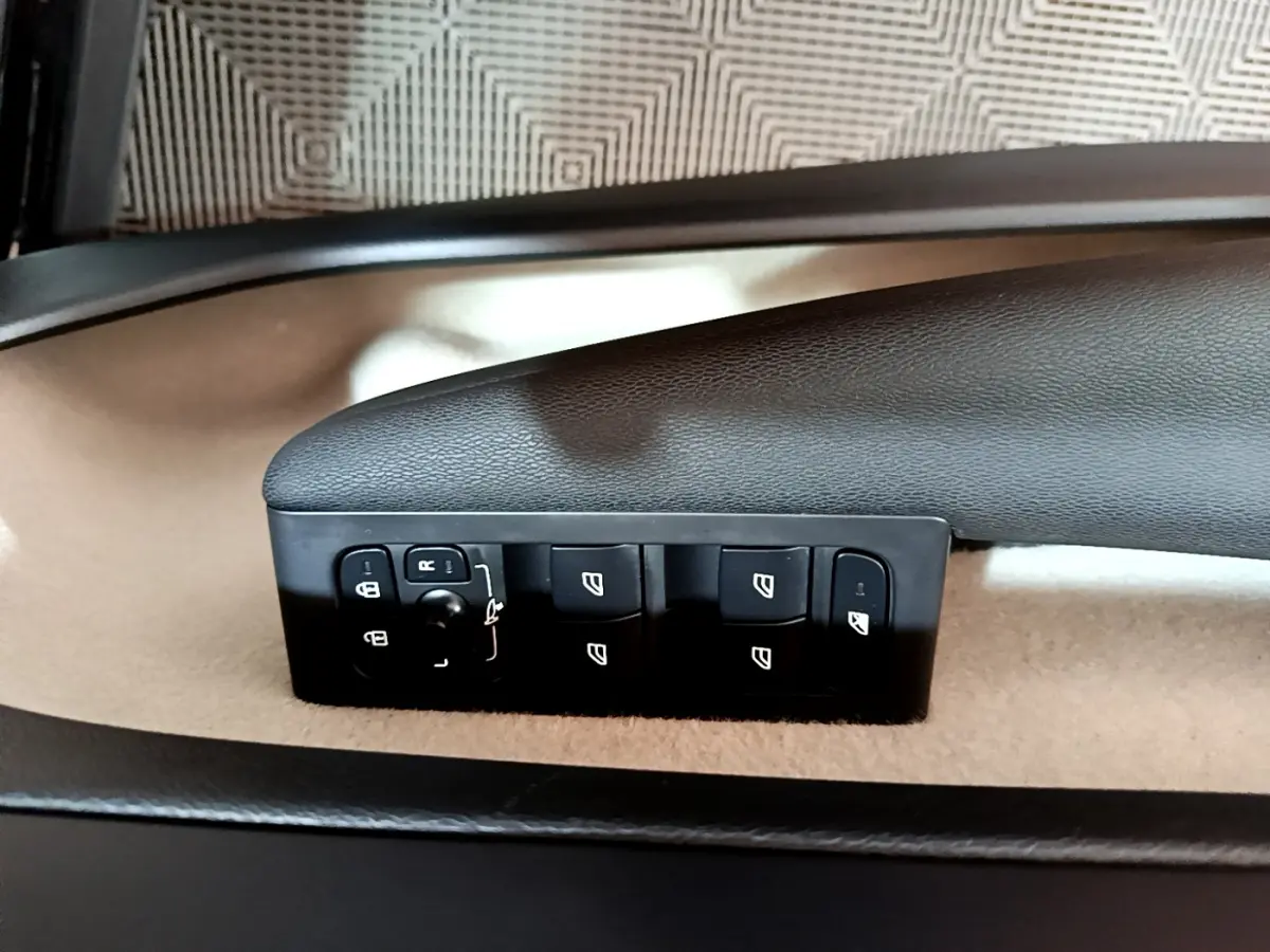 Commandes des vitres et rétroviseurs sur la porte côté conducteur d'un Volvo XC40 T3 noir, intérieur beige et noir.