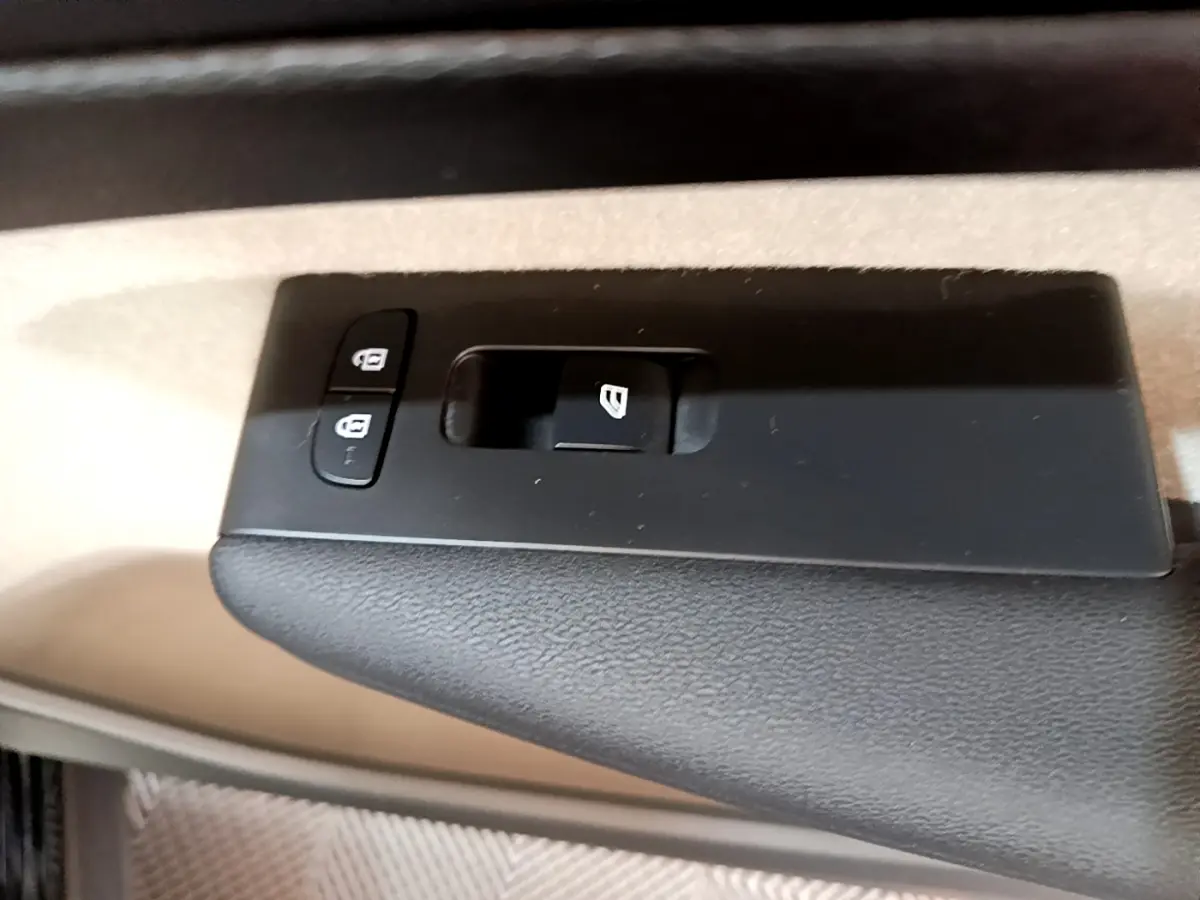 Gros plan sur les commandes de verrouillage et lève-vitre côté conducteur du Volvo XC40 T3 noir, intérieur beige.